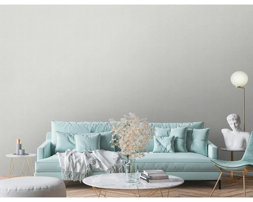 Ljust vardagsrum med soffa, fåtölj, sidobord och dekoration