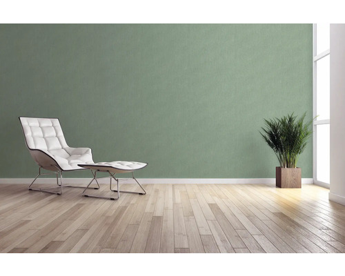 Ljust rum med fåtölj, fotpall, krukväxt och väggbeklädnad