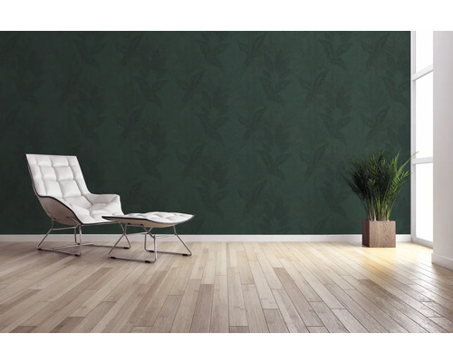 Vardagsrum med grön blad tapet, fåtölj, fotpall, krukväxt och trägolv