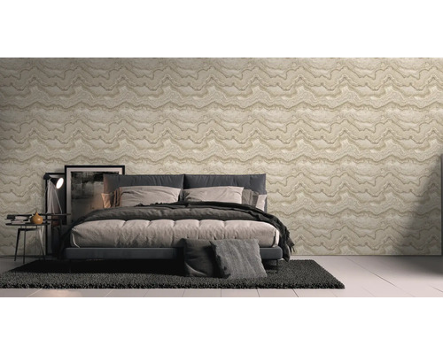 Sovrum med en vägg med mönstrad tapet, säng och matta.