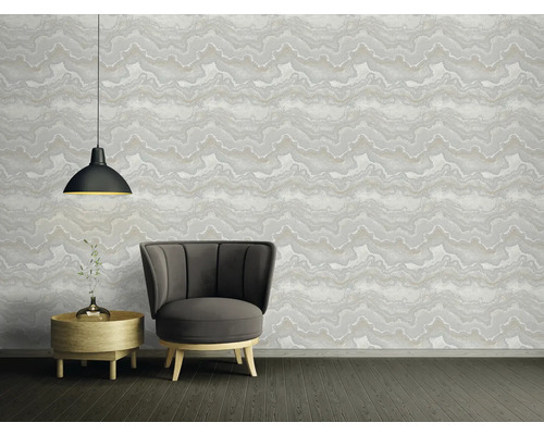 Vardagsrum med fåtölj, sidobord och mönstrad tapet