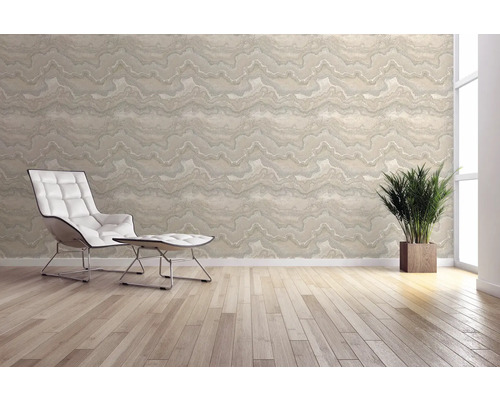 Ljust rum med mönstrad tapet, fåtölj och krukväxt