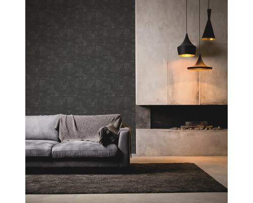 Vardagsrum med grå soffa, filt, mörk tapet, öppen spis och tre hängande lampor