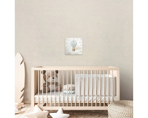 Barnrum med canvastavla av en luftballong ovanför en spjälsäng.