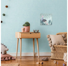 Dekorativ barnrumsscen med sidobord i trä, canvastryck, krukväxter och rottingfåtölj