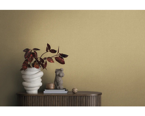 Närbild av ett rum med strukturtapet, en skänk, en blomvas och dekorativa element.