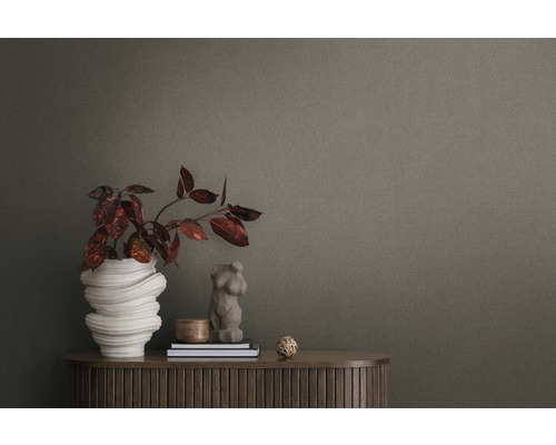 Närbild av en texturerad tapet med dekorativa element på ett träskåp