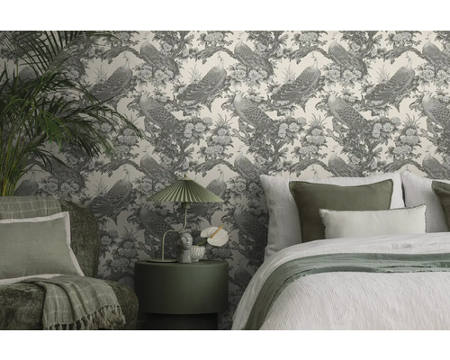 Dekorativt sovrum med mönstrad tapet, säng och sidobord.