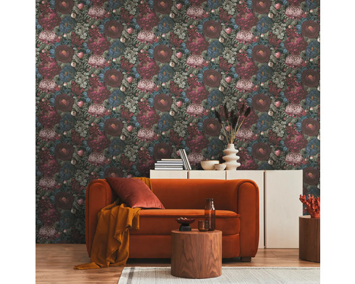 Vardagsrum med blommönstrad tapet, orange soffa och träbord på en matta