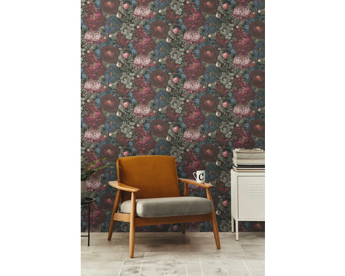 Vardagsrum med blommig tapet, fåtölj och sidobord