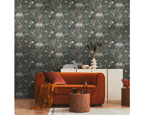 Vardagsrum med blommönstrad tapet, soffa och sidobord