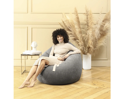 Kvinna sitter i en grå sittsäck i ett ljust rum