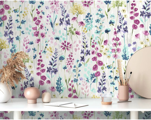 Scen med blommönstrad tapet, skrivbord, dekoration och kontorsmaterial.