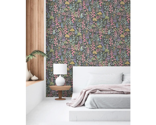 Sovrum med blommönstrad tapet, säng och sängbord med lampa