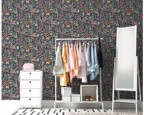 Dekorativ rumsscen med blommig tapet, byrå, klädställning och spegel