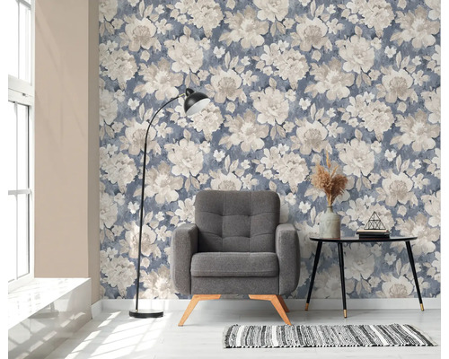 Vardagsrum med blommig tapet, fåtölj, golvlampa och bord