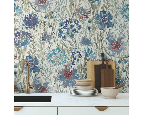 Köksscen med blommig tapet, diskho, porslin och skärbrädor.