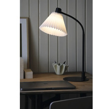Bordslampa med plisserad lampskärm på ett skrivbord