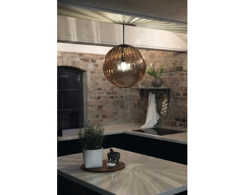 Modernt kök med rund hänglampa, örtkruka och tegelvägg