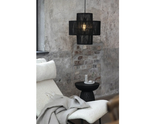 Rumsscen med svart hänglampa, fåtölj och sidobord