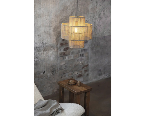 Interiörbild med en hängande lampa i två nivåer och en träpall.