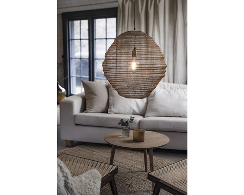 Vardagsrum med soffa, bord och hängande lampa av flätat material