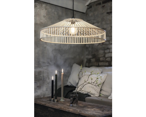 Hänglampa av ljust trä över bord med ljus och dekoration