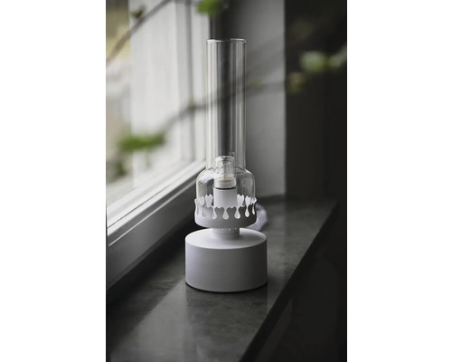 Dekorativ bordslampa med glascylinder på fönsterbräda