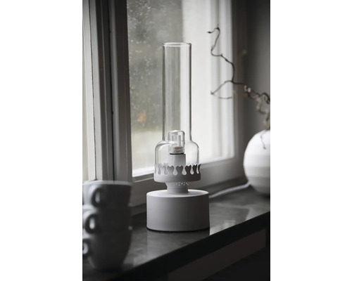 Dekorativ lampa med glasskärm på fönsterbrädan