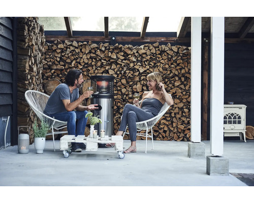 Terrass med uteplatsvärmare, vedstapel och sittplatser för två personer