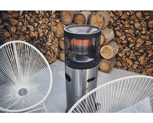 Uteplats med terrassvärmare, stolar och stapel med ved