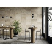 Ljust rum med golvplattor och väggplattor i naturstenslook, bord och stolar