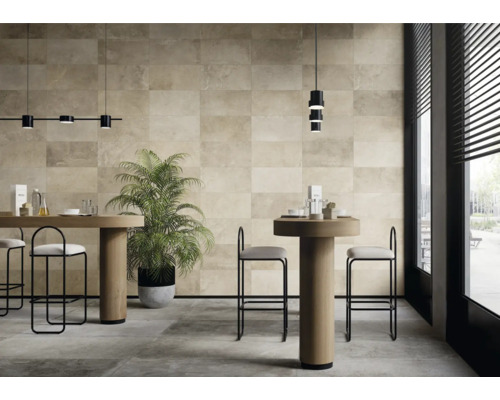 Ljust rum med golvplattor och väggplattor i naturstenslook, bord och stolar