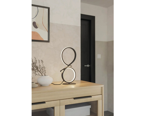 Dekorativ bordslampa i modern design på ett träskåp