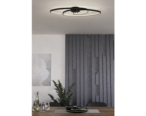 Modern vardagsrumsscen med en LED-taklampa ovanför ett matbord.