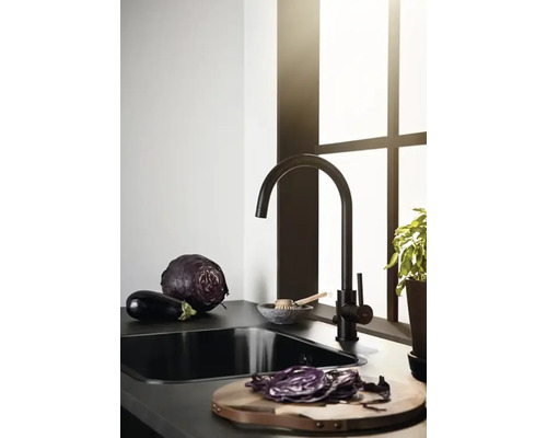 Köksscen med diskho, blandare, grönsaker och skärbräda