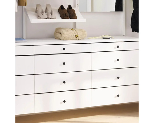 Vit garderob med lådor, skor och stickad kofta