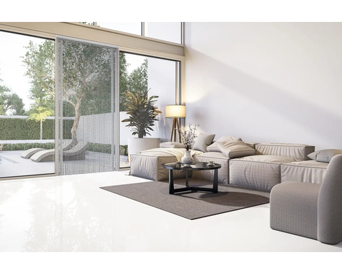 Ljust vardagsrum med soffa, bord, golvlampa och gardin