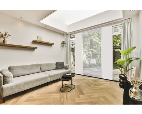 Vardagsrum med soffa, soffbord, trähyllor och rullgardiner