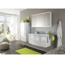 Ljust badrum med vitt tvättställsskåp, spegelskåp, högskåp och fönster