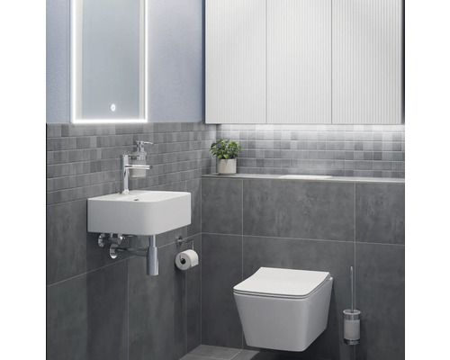 Modernt badrum med handfat, toalett och spegel