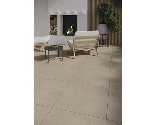 Ljus uteplats med golvplattor, fåtöljer och öppen spis