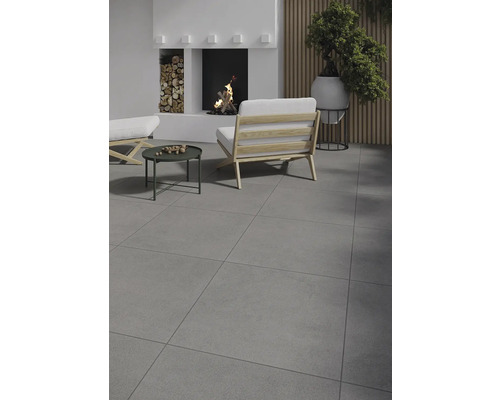 Vardagsrum med klinkergolv, öppen spis, fåtölj och sidobord