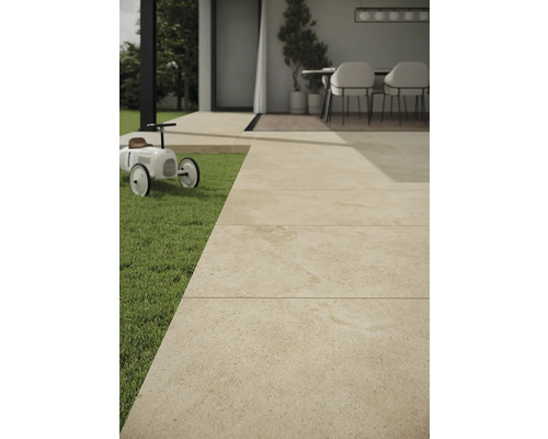 Utomhusområde med stenplattor, gräsmatta och leksaksbil