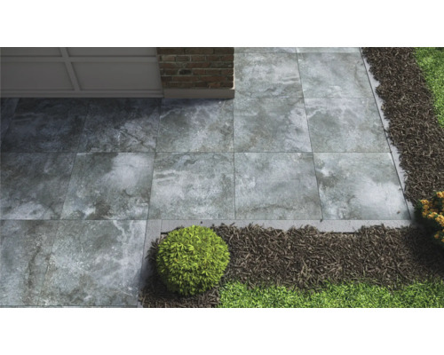 Trädgårdsgång med grå stenplattor, grus och grönska