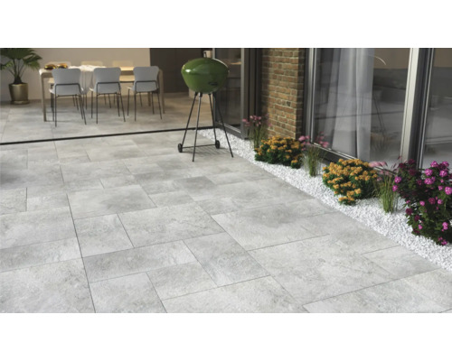 Terrass med stenplattor, grill och sittgrupp