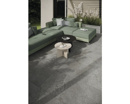 Utomhusscen med modulsoffa, två runda sidobord och golvplattor.