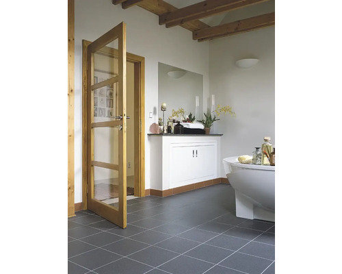 Badrum med badkar, tvättställ och trädörr med glasinsatser