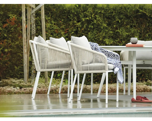 Terrass med bord och stolar med repklädsel och kuddar