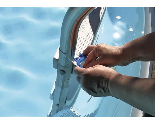 En person fäster en blå termometer med kabel på en poolstege